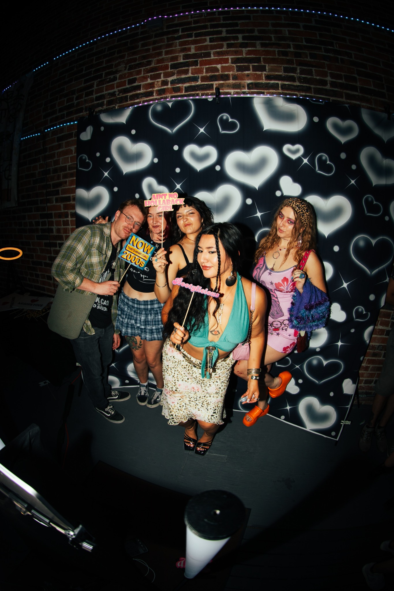Friends posing at a TOMBOY photobooth